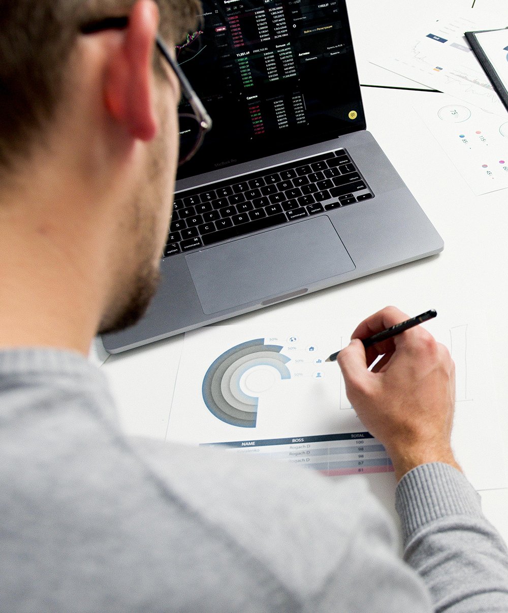 Marketing analyst reviewing B2B attribution data and customer journey analytics on laptop and charts